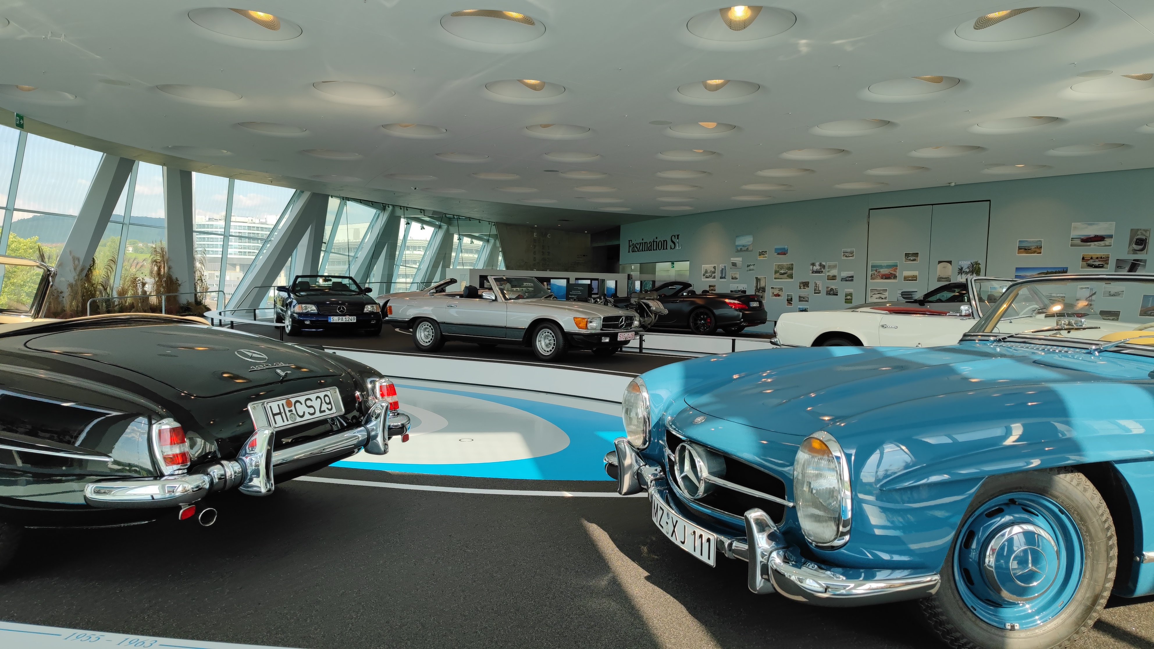 Exhibition of older Mercedes models in a museum.