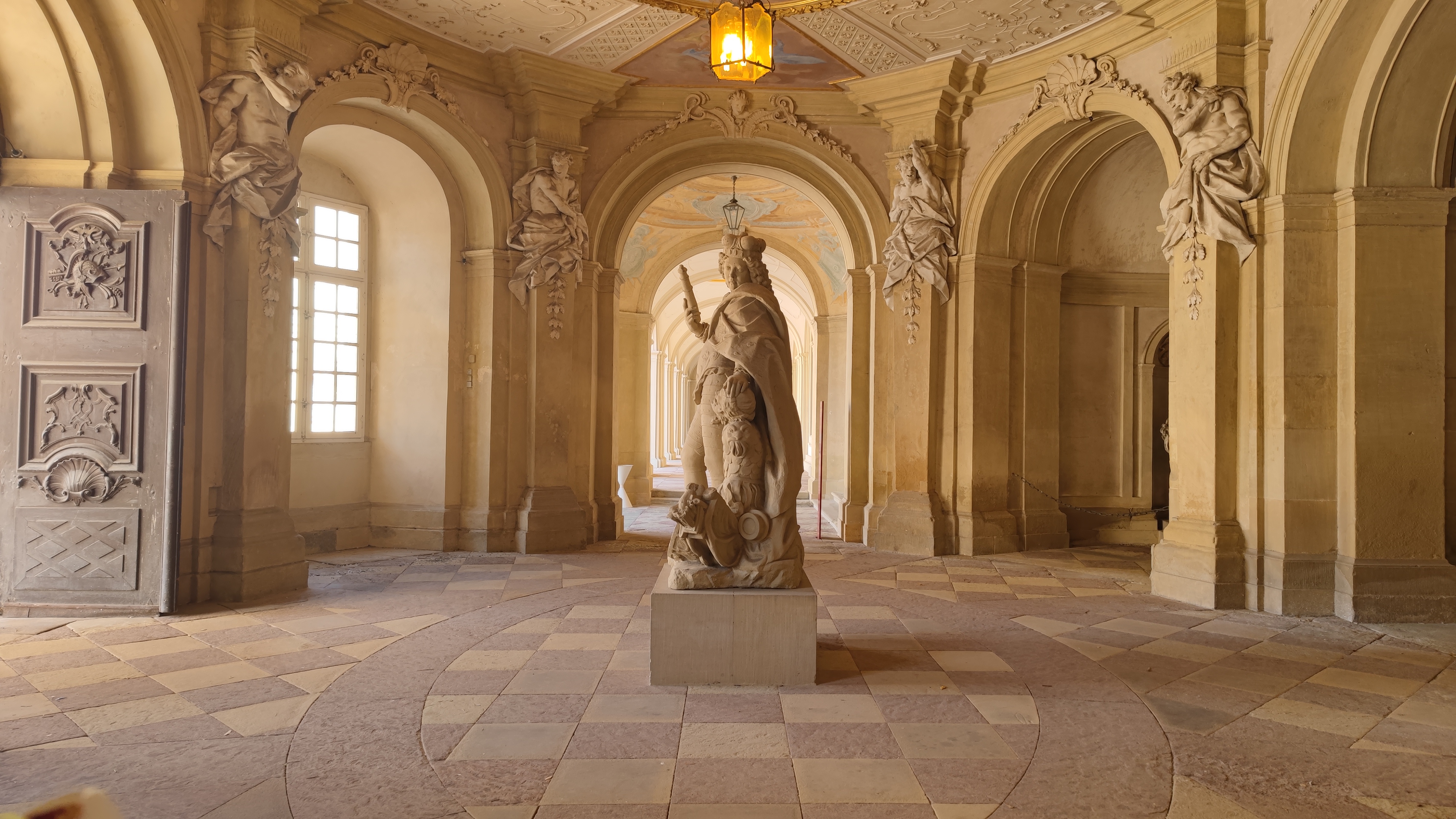 A statue in the middle of the aisle of a palace.