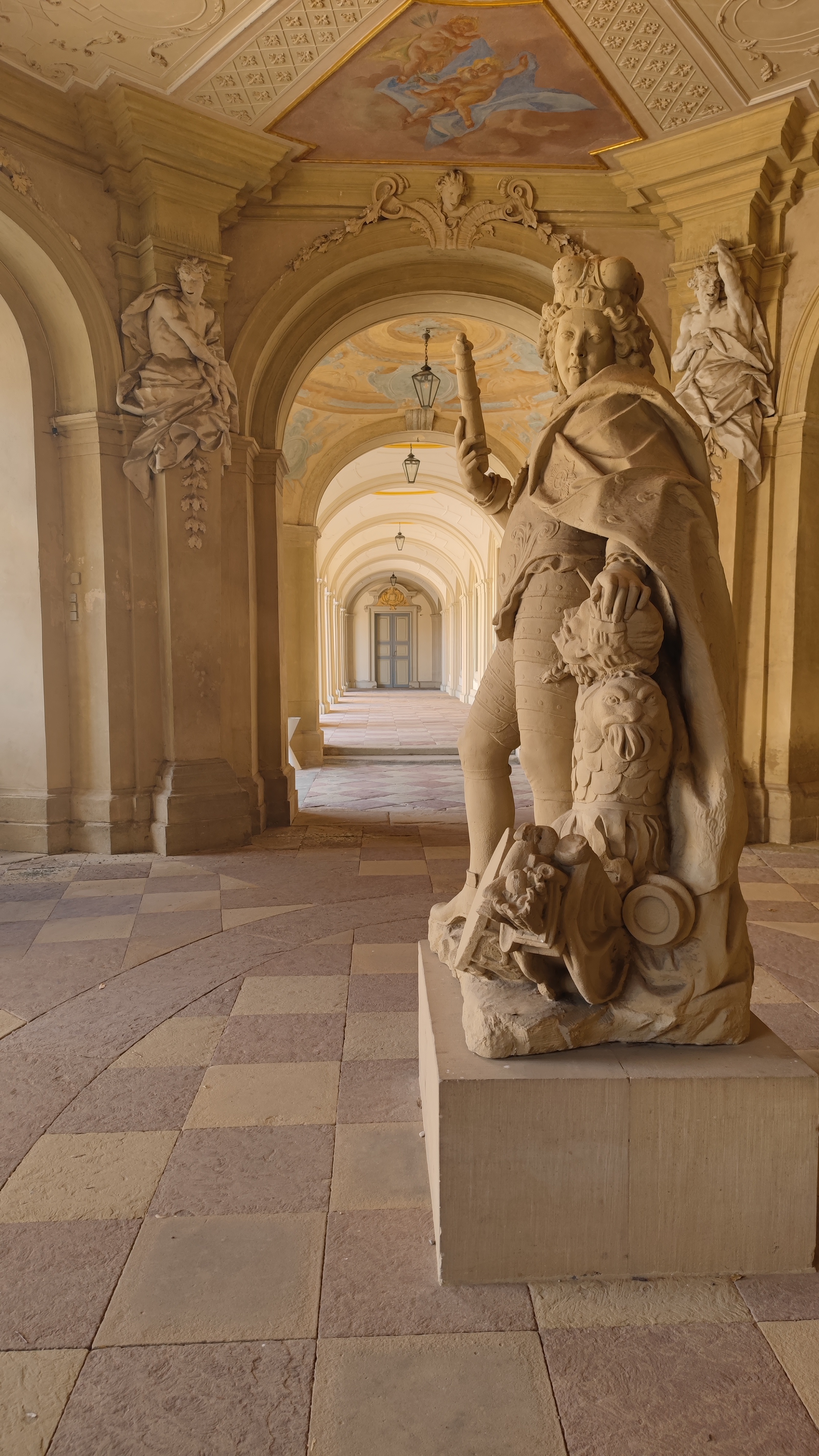 A statue in the middle of the aisle of a palace.