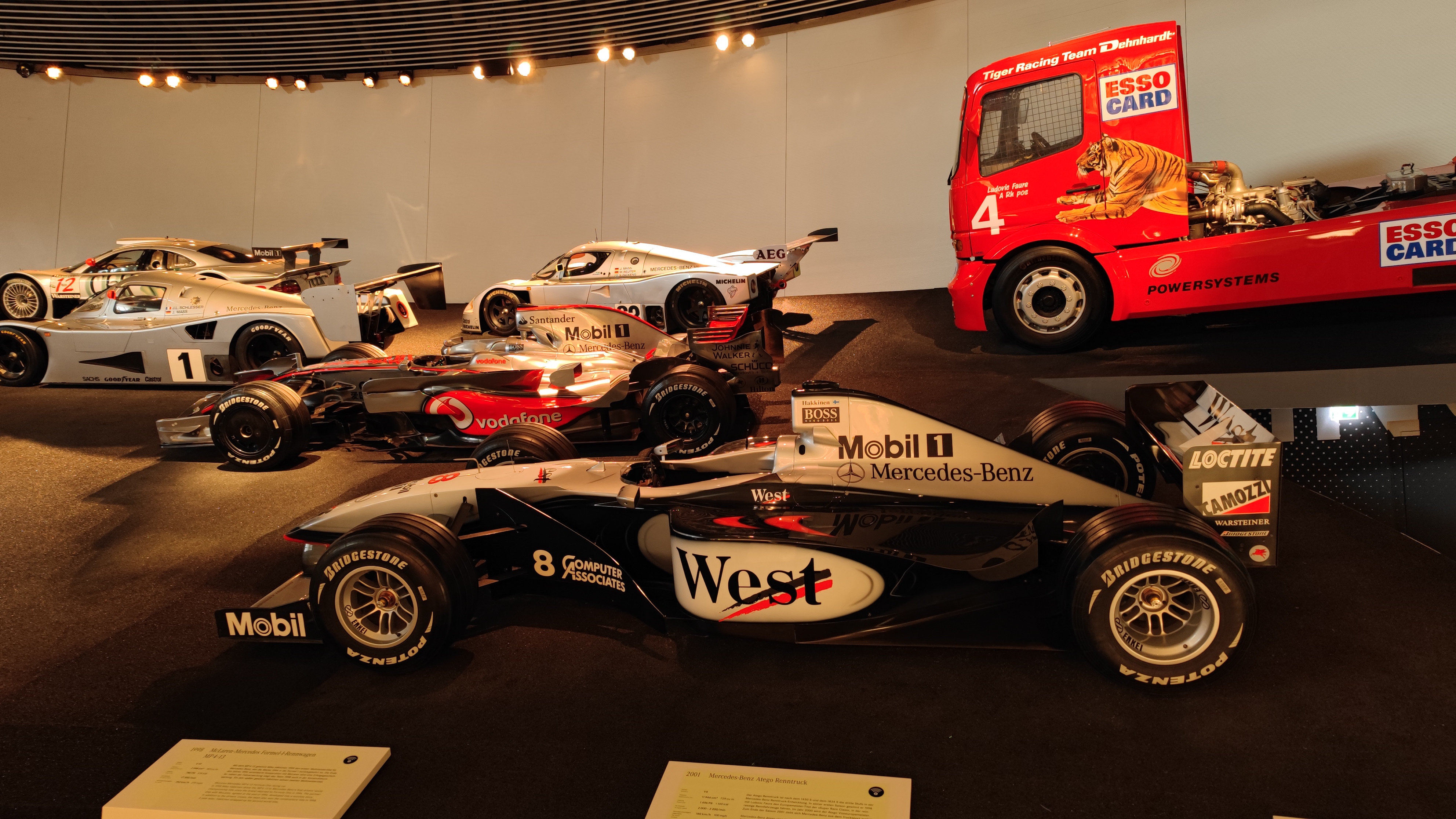 Exhibition of Formula-1 and other race cars in a museum.