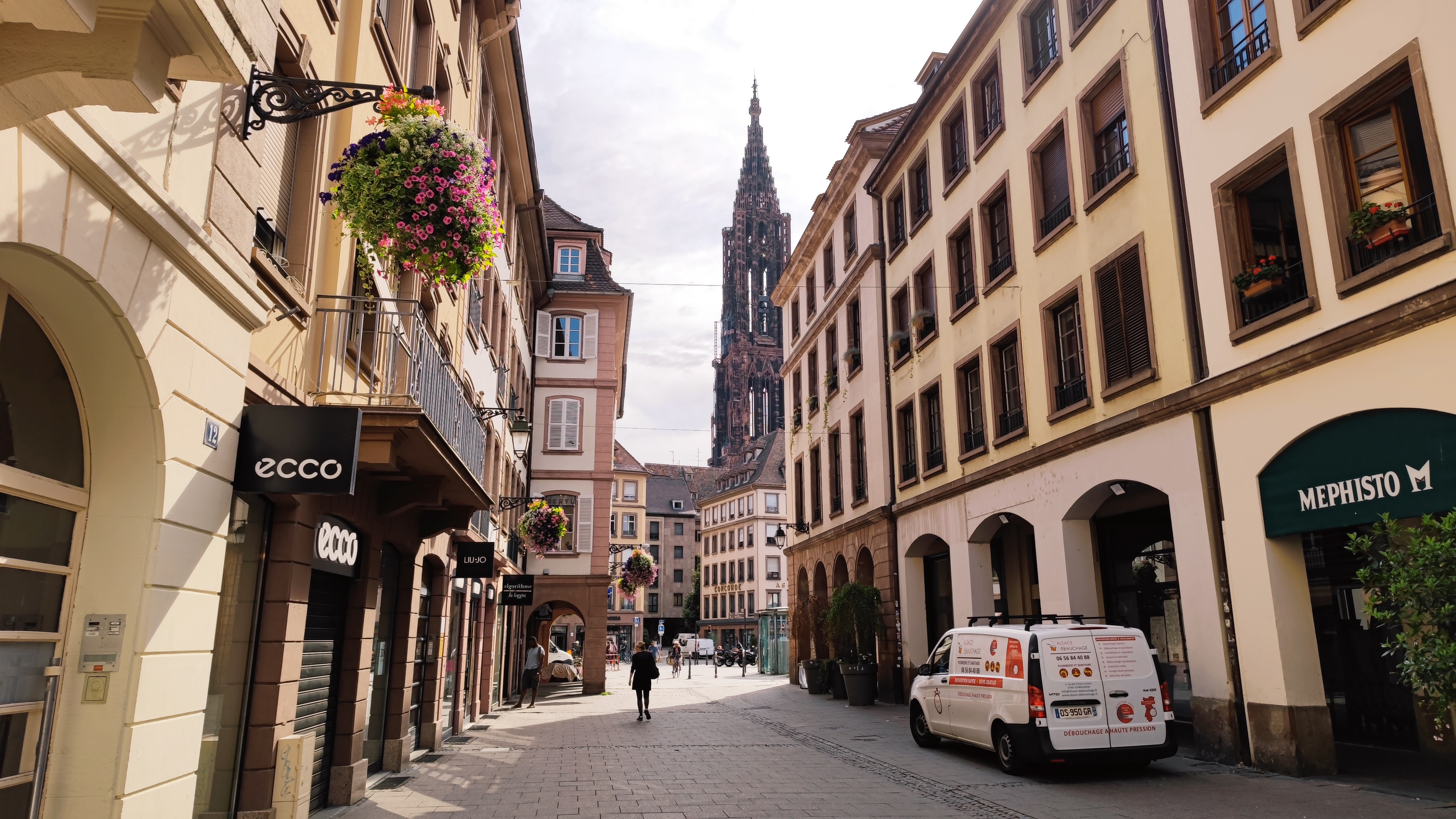 A walking street, with the main spire of the cathedral emerging above the buildings.