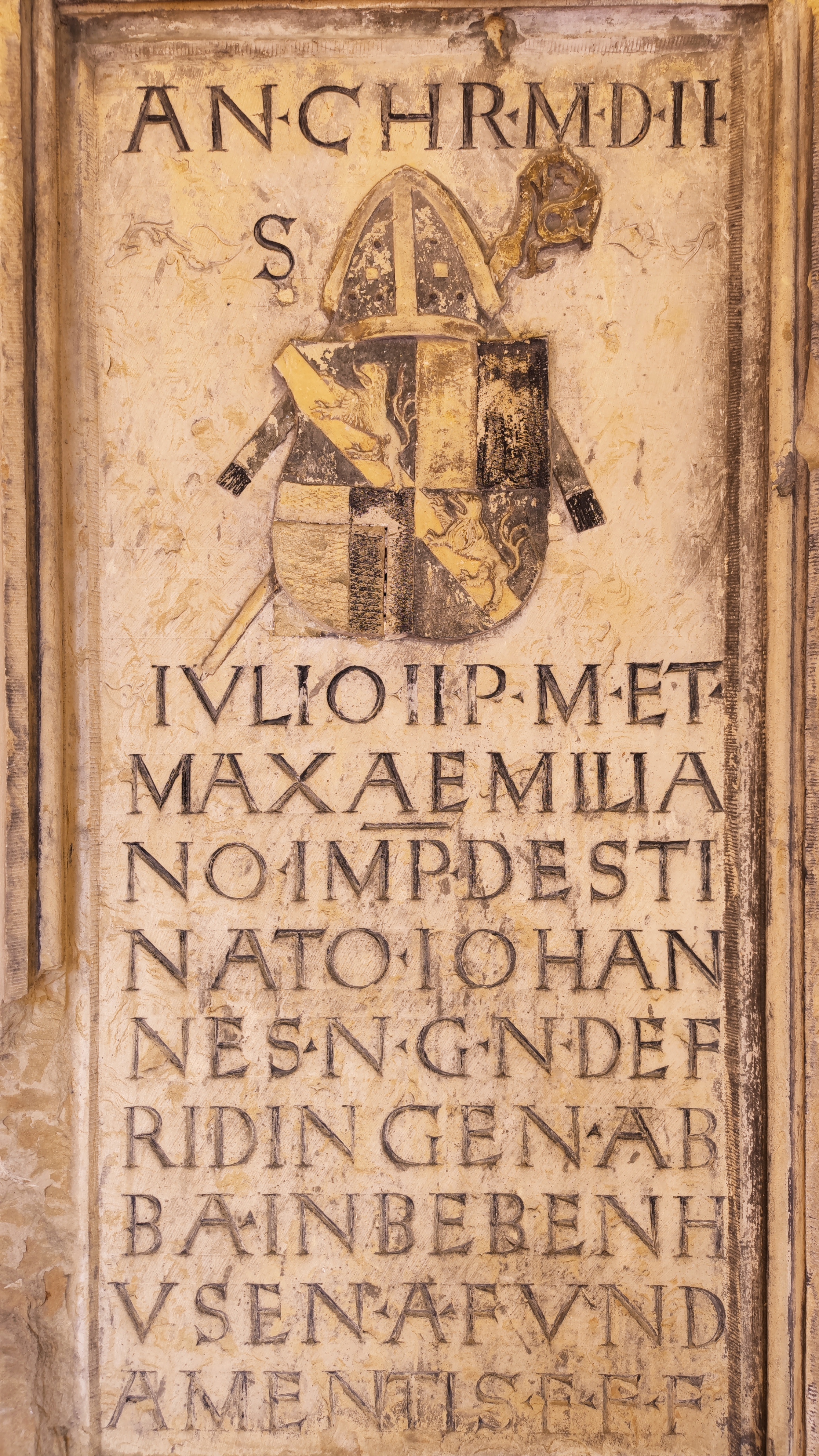 Engraved stone slab. A coat of arms and a Latin text are on it.