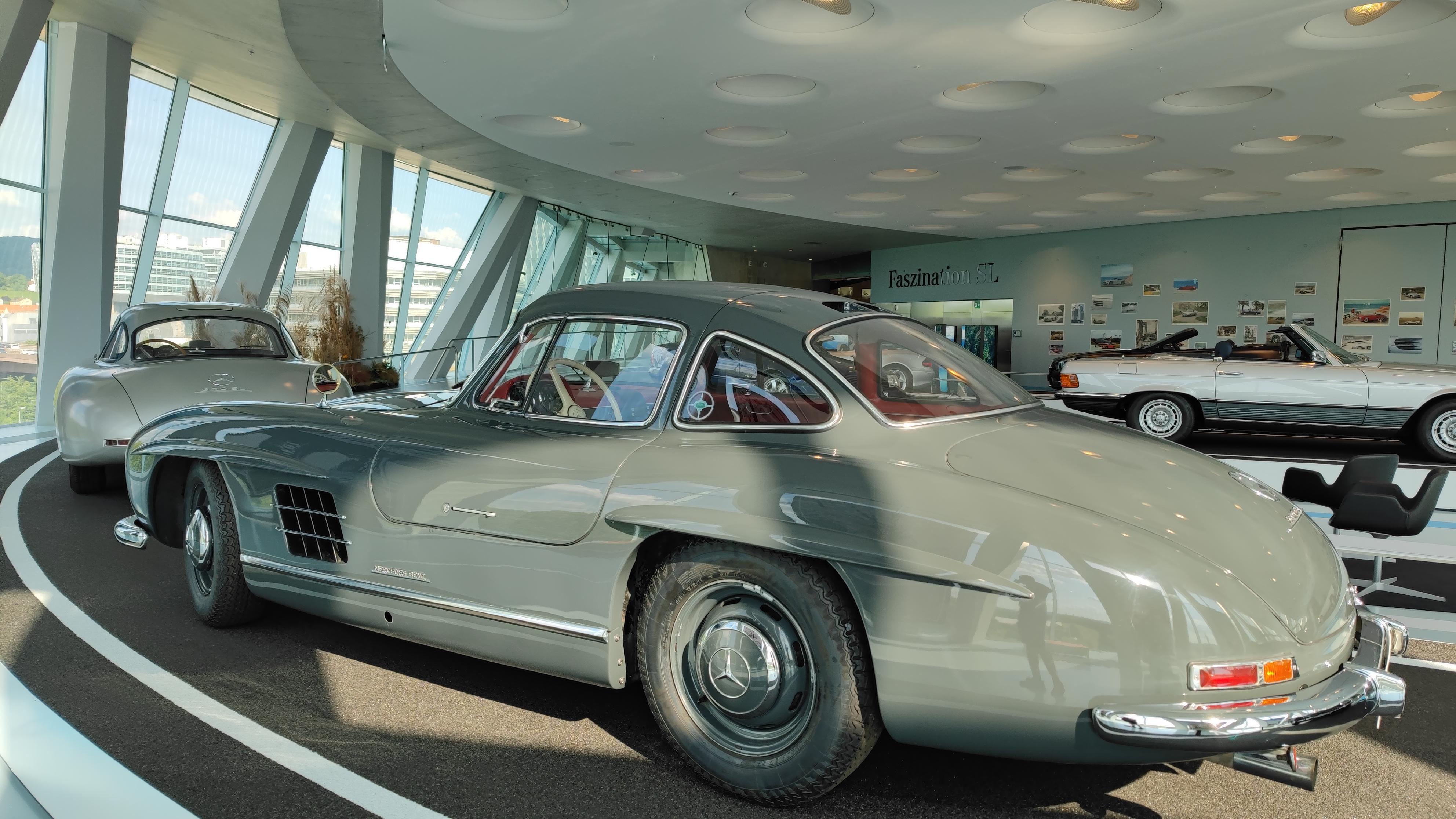 Exhibition of older Mercedes models in a museum.