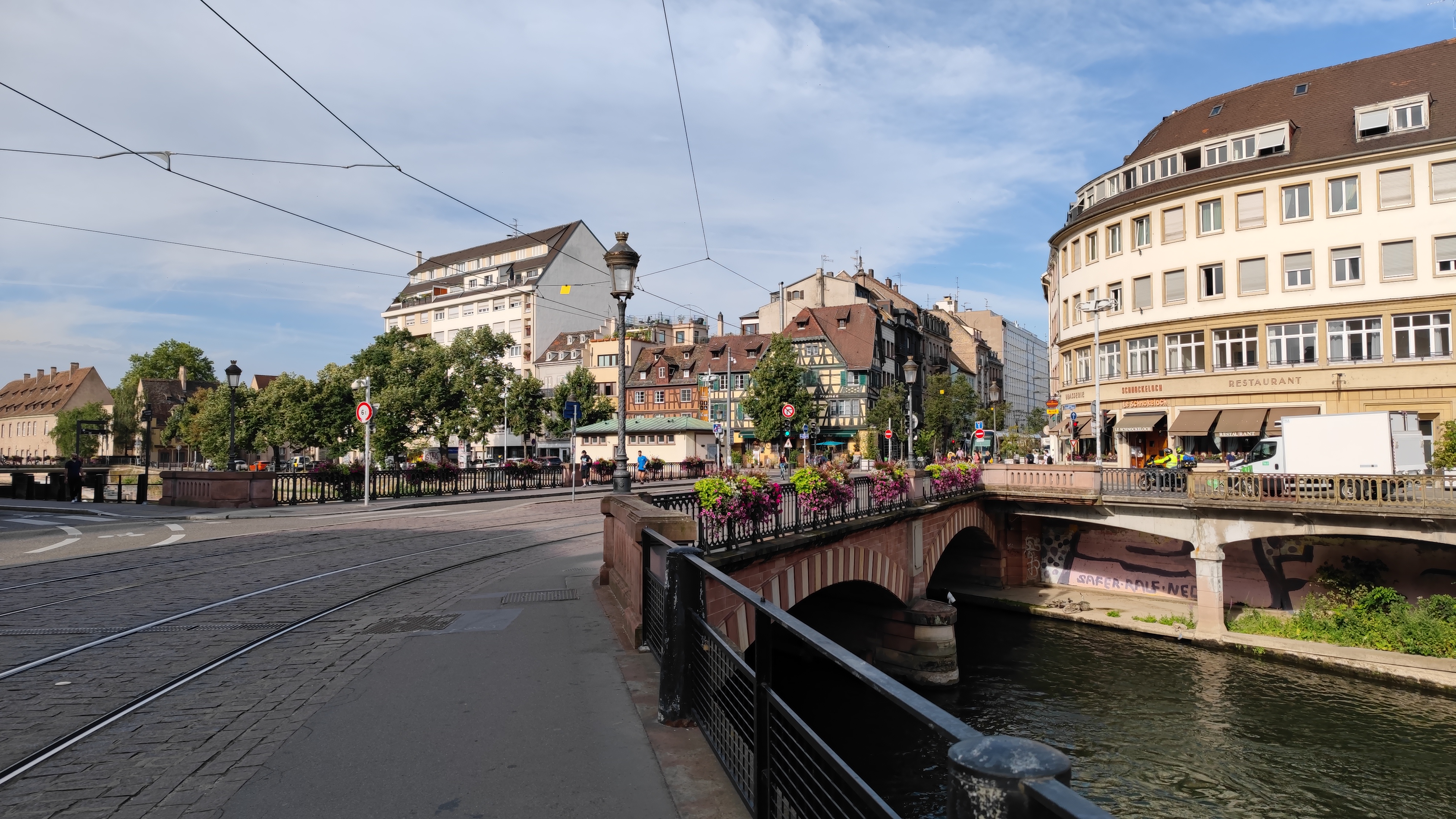 A small bridge with tram lines on it over a canal.