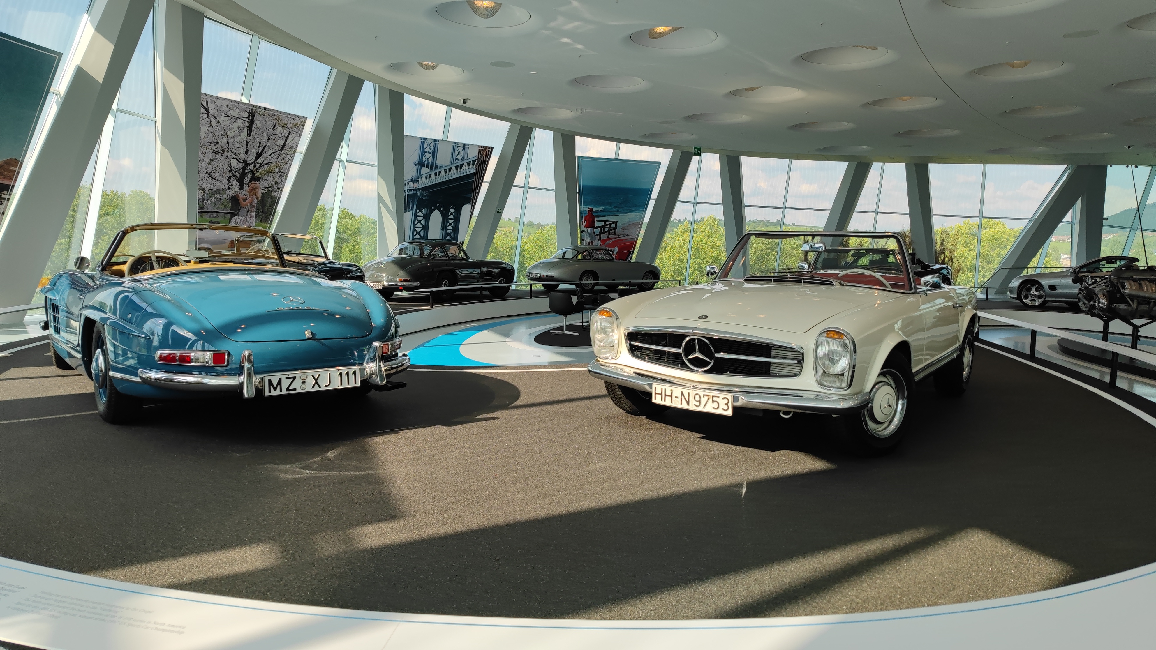 Exhibition of older Mercedes models in a museum.