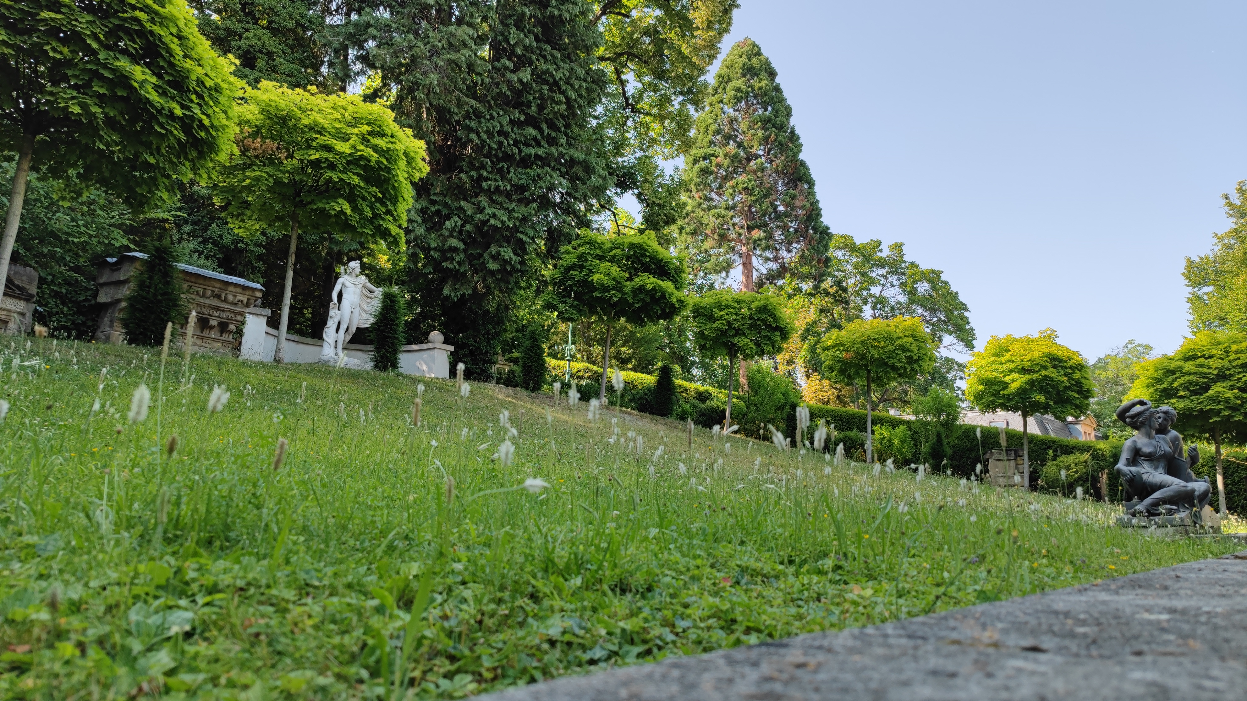 Small park with statues and trees.