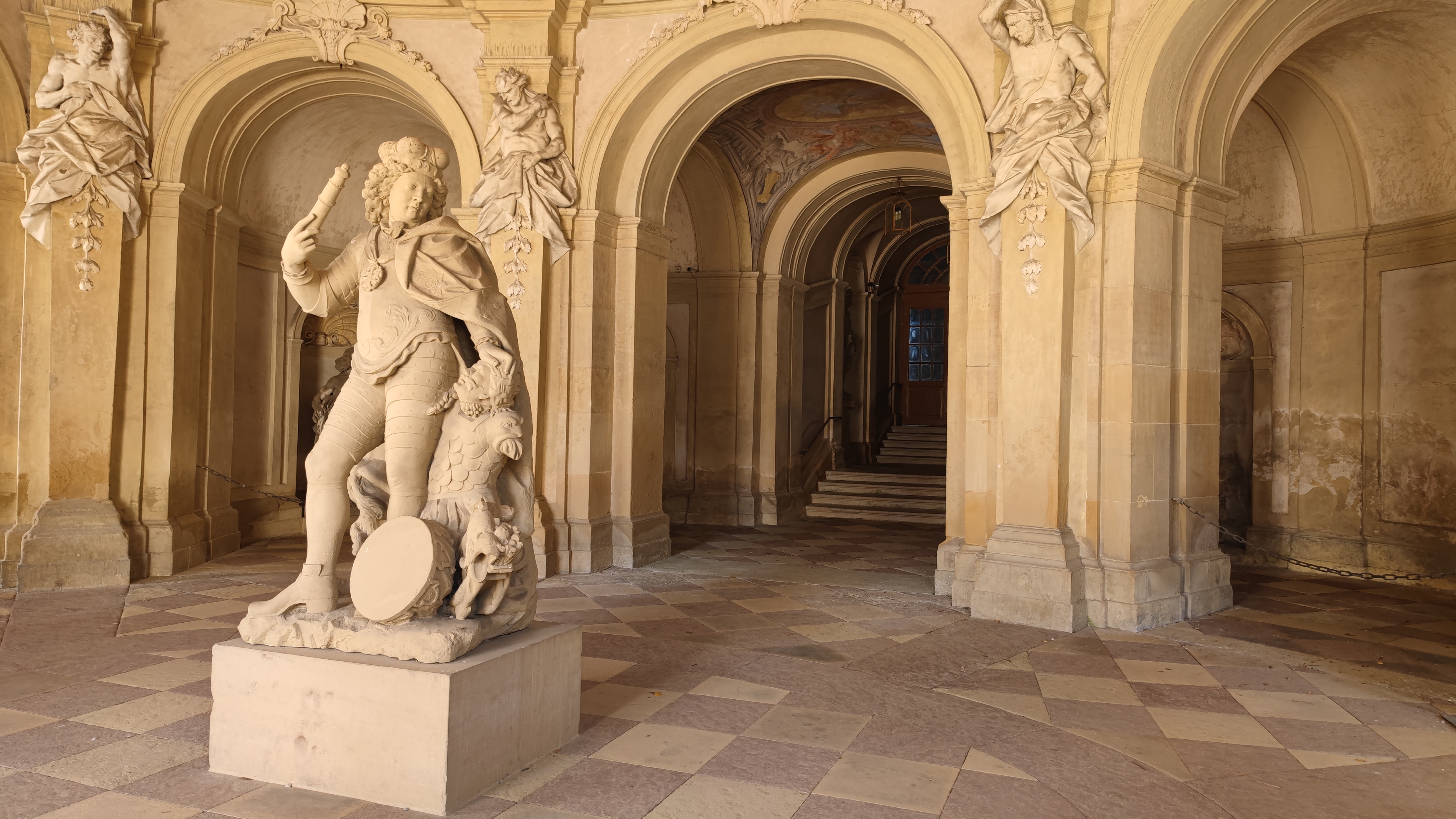 A statue in the middle of the aisle of a palace.