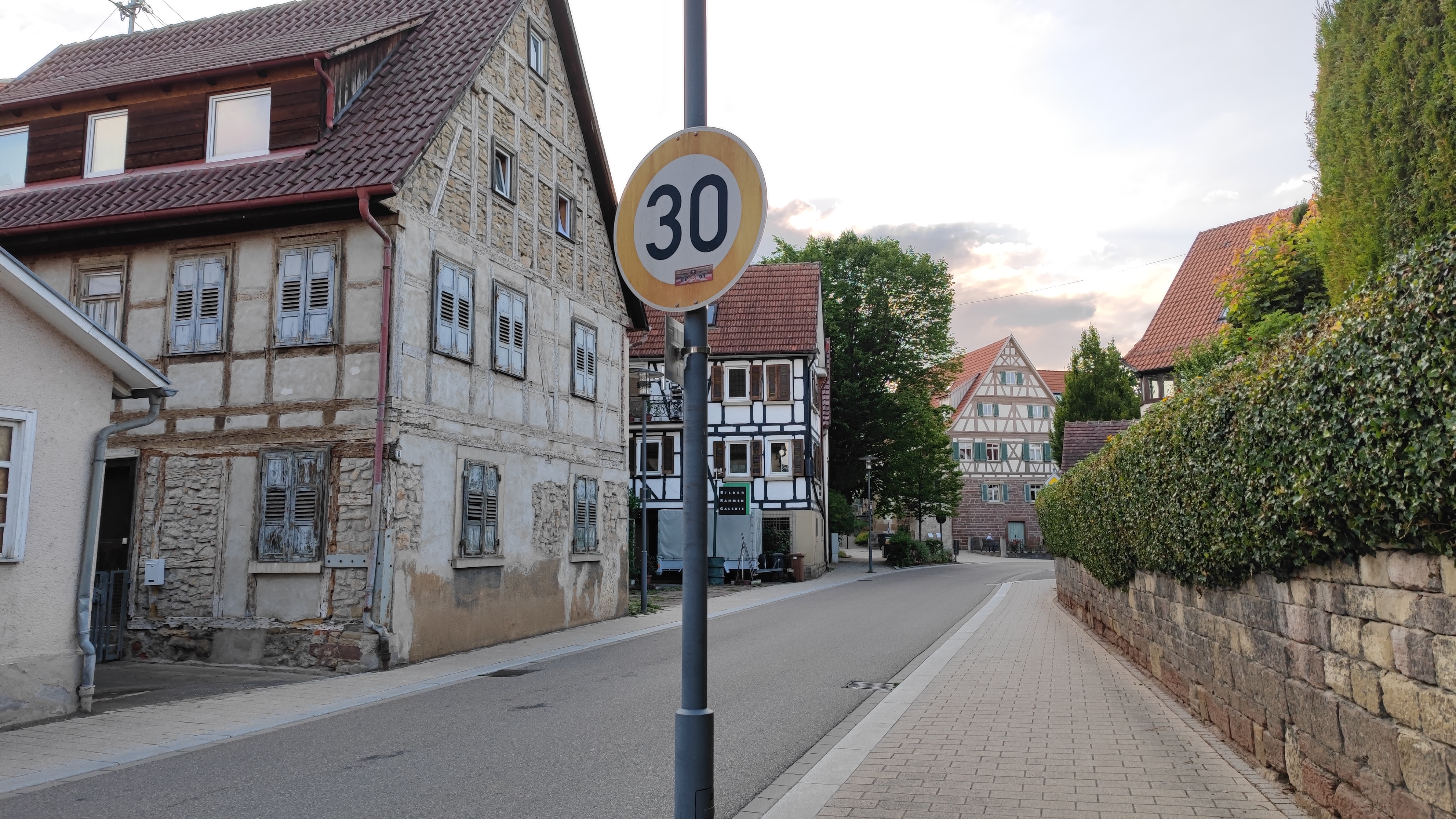 A little Southern-German town with traditional buildings. A speed limit of 30 sign is in the foreground.